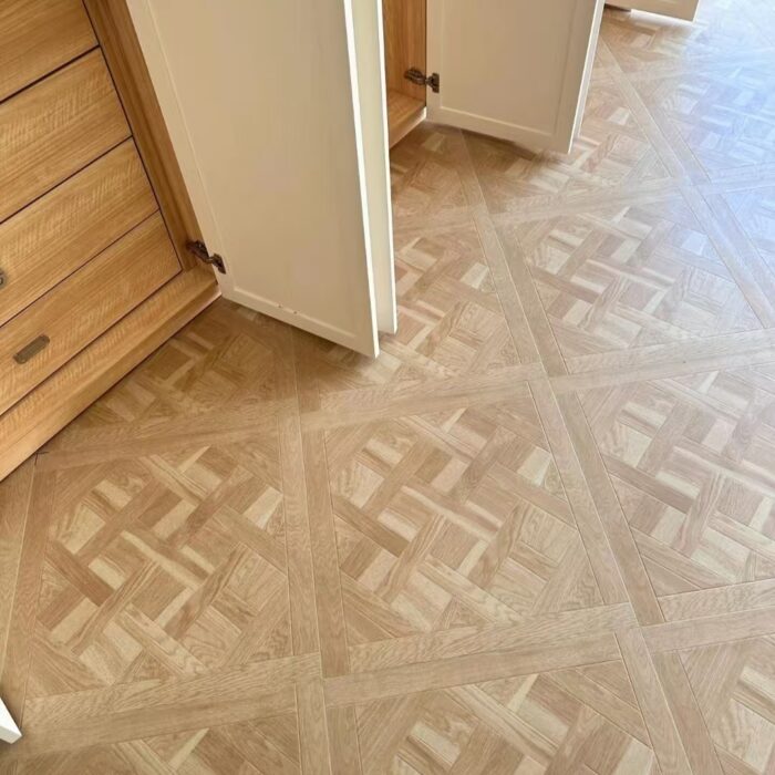 Solid oak Versailles flooring installed in interior space, showing geometric parquet panel layout and natural wood grain