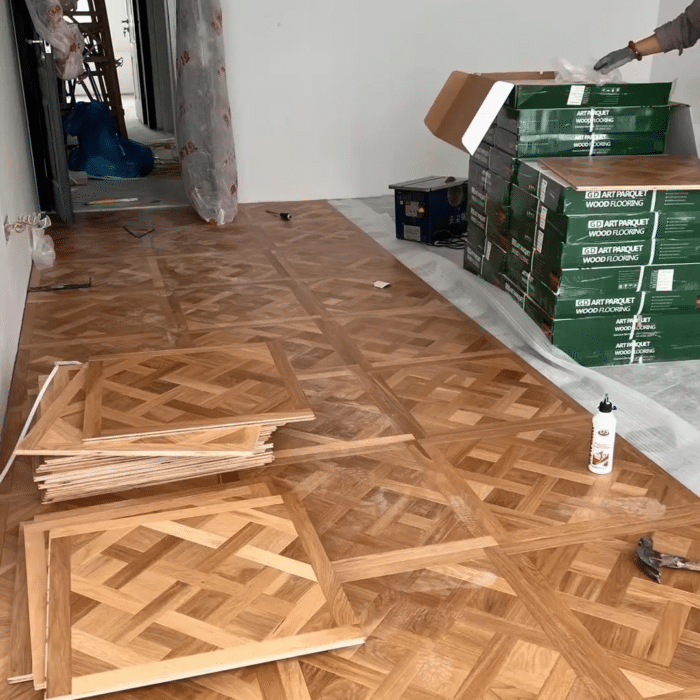 Solid oak Versailles flooring installed in interior space, showing geometric parquet panel layout and natural wood grain