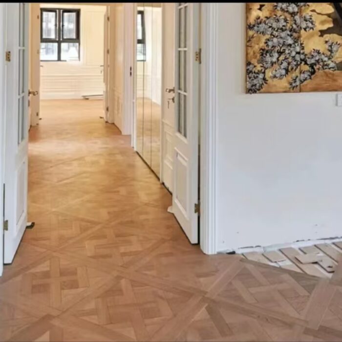 Solid oak Versailles flooring installed in interior space, showing geometric parquet panel layout and natural wood grain