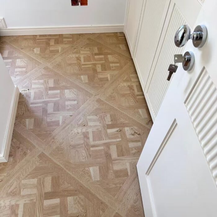 Solid oak Versailles flooring installed in interior space, showing geometric parquet panel layout and natural wood grain